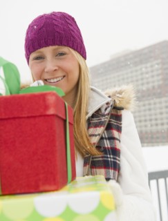 Woman holding christmas gifts. Photo : Jamie Grill Photography