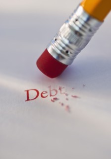 Studio shot of pencil erasing the word debt from piece of paper. Photo : Daniel Grill