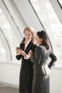 Businesswomen looking at cell phone. Photo: Mark Edward Atkinson