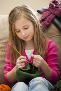 Girl (8-9) knitting woolly hat. Photo: Mike Kemp