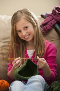 Girl (8-9) knitting woolly hat. Photo: Mike Kemp