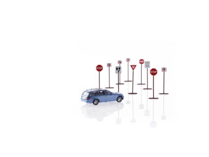 Studio shot of toy road signs and car. Photo : David Arky