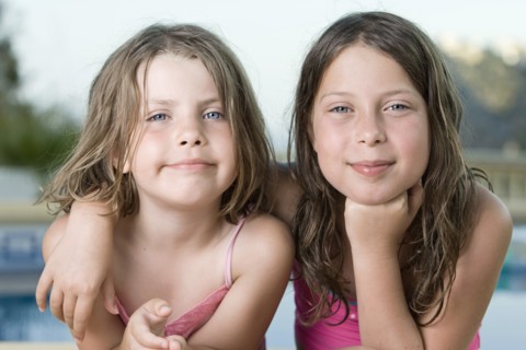 Two girls (6-7,8-9) embracing. Photo : Justin Paget