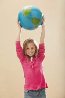Studio portrait of girl (8-9) holding globe. Photo : Mike Kemp