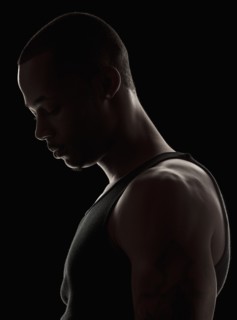 Studio shot of muscular young man wearing tank top. Photo : Mike Kemp
