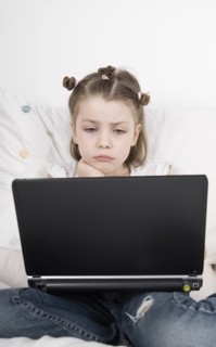 Girl (6-7) sitting with laptop. Photo : Justin Paget