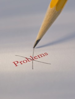 Studio shot of pencil crossing out the word problems from piece of paper. Photo : Daniel Grill