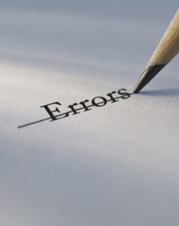 Studio shot of pencil crossing out the word errors from piece of paper. Photo : Daniel Grill