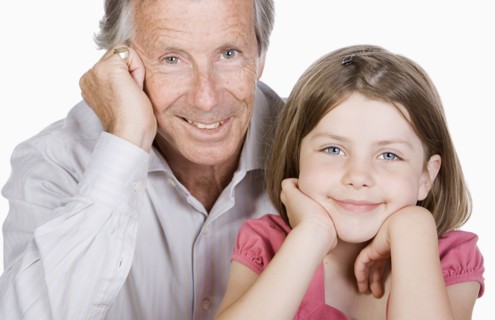 Studio portrait of senior man with granddaughter (6-7). Photo : Justin Paget