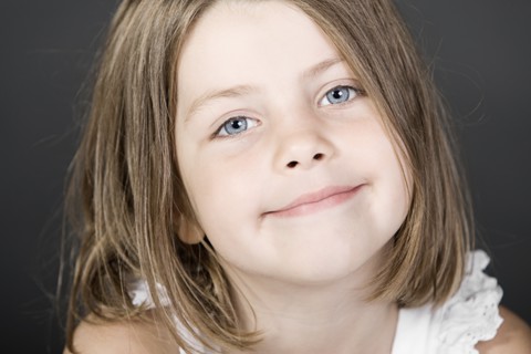 Studio portrait of smiling girl (6-7). Photo : Justin Paget