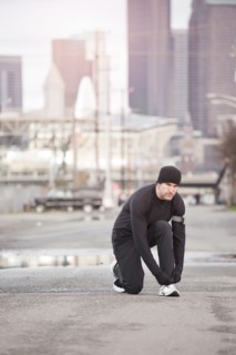 USA, Washington, Seattle, man tying shoelace in street. Photo : Take A Pix Media