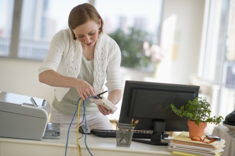 Woman installing router at home office.