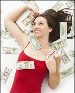 Young woman lying in money. Photo: Mike Kemp