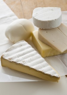 Various cheeses on table.