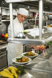 Chef preparing food in kitchen.