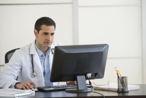 Doctor using computer in office.