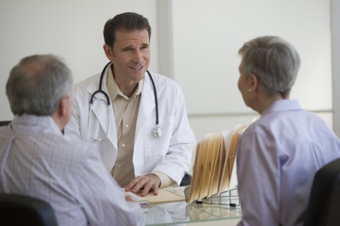 Doctor and senior couple talking in office.