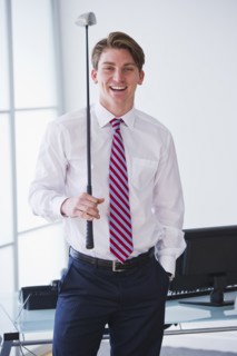 Portrait of young businessman holding golf club. Photo : Daniel Grill