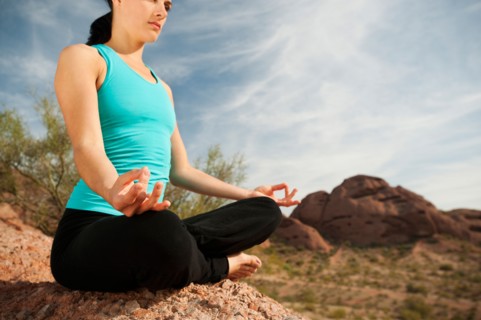 USA, Arizona, Phoenix, Young woman practicing yoga on desert.