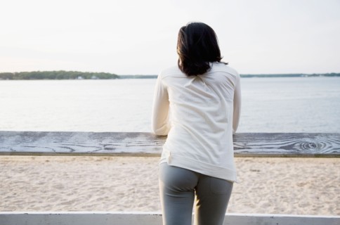 USA, New York State, Long Island, woman leaning against rail fence and looking at lake. Photo :