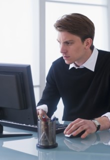 Man working on computer at office. Photo : Daniel Grill