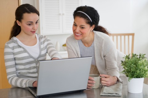 Mother with teenage daughter (14-15) working on laptop.