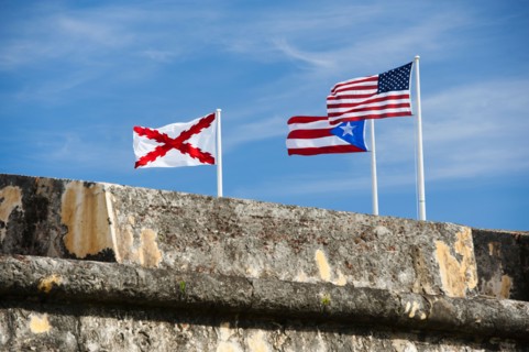 Puerto Rico, Old San Juan, El Morro Fortress, flags behind wall.