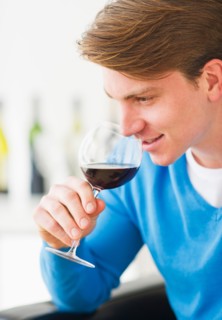 Young man tasting red wine. Photo : Daniel Grill