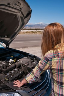 USA, California, Palm Springs, Woman standing in front of broken car in desert. Photo : Daniel