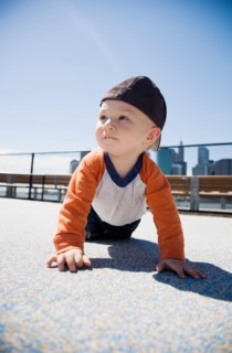 USA, New York City, Brooklyn, baby boy (0-1 years) crawling on sidewalk. Photo : Maisie Paterson