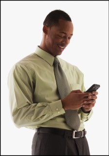 Young businessman using mobile phone . Photo : Mike Kemp