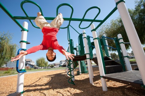 USA, California, Boy (12-13) climbing at playground. Photo : Noah Clayton