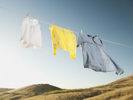 Laundry hanging on clothesline against blue sky.