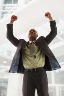 Successful young businessman cheering. Photo : Mike Kemp