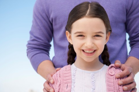 Portrait daughter (8-9) embraced by father.