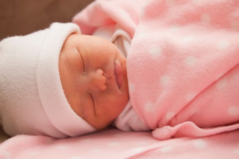 Baby girl (0-1 month) sleeping on sofa. Photo : Mike Kemp