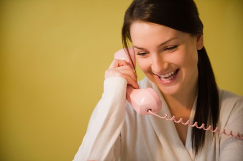 Smiling young woman talking on phone. Photo : Jamie Grill Photography