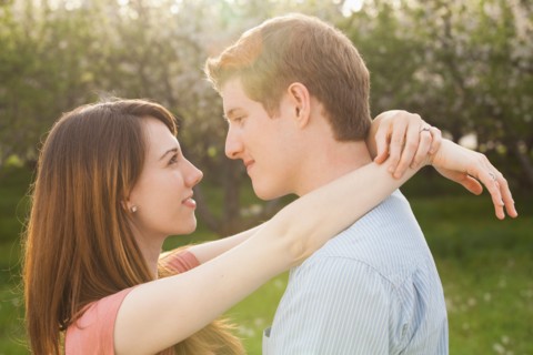 Young couple embracing in orchard. Photo : Mike Kemp