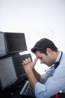 Upset financial worker analyzing data displayed on computer screen.