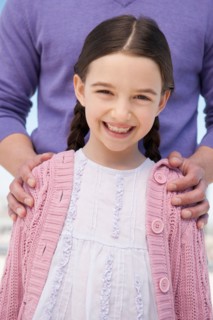 Portrait daughter (8-9) embraced by father.