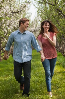 USA, Utah, Provo, Young couple walking through orchard. Photo : Mike Kemp