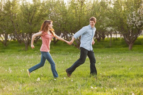 USA, Utah, Provo, Young couple running through orchard. Photo : Mike Kemp