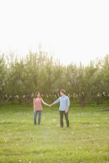 USA, Utah, Provo, Young couple walking through orchard. Photo : Mike Kemp
