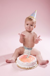 Baby girl (12-17 months) with first birthday cake. Photo : King Lawrence