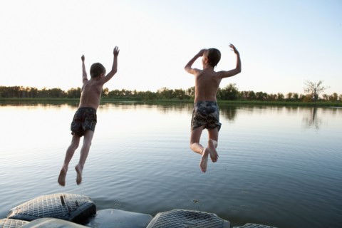 USA, Texas, Texarkana, Two boys (8-9) jumping into lake. Photo : King Lawrence