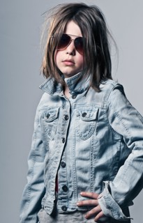 Girl (8-9) posing in oversized denim jacket an sunglasses . Photo : Justin Paget
