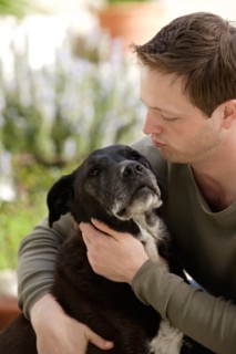 Dog licking man. Photo : Rob Lewine
