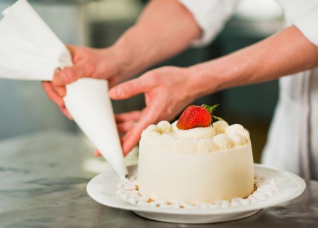 Pastry chef decorating cake.