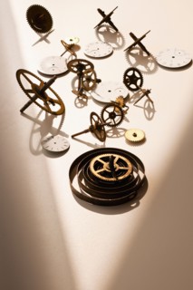 Close up of gears and clock parts on white background.