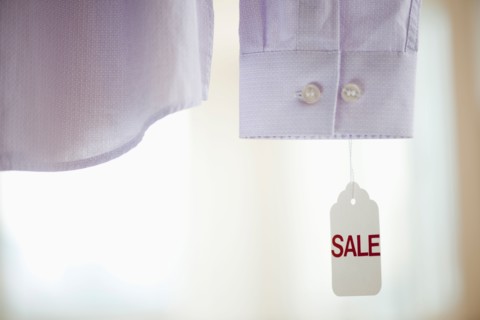 Close up of shirt cuff with sale tag.